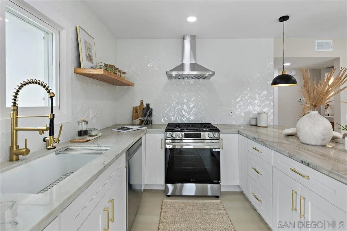 3663 Oleander Drive San Diego, CA 92106 - Photo 13 of 46 a kitchen with stainless steel appliances granite countertop a sink a stove and a wooden floors