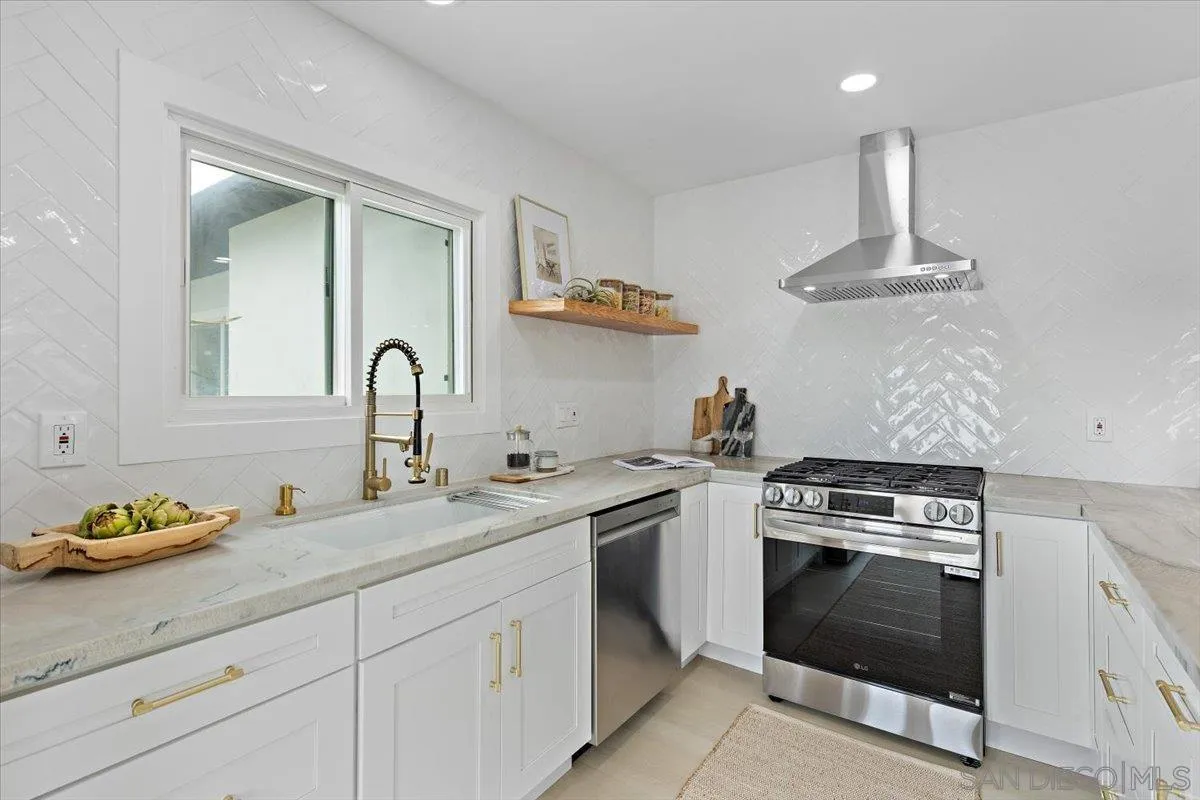 3663 Oleander Drive San Diego, CA 92106 - Photo 14 of 46 a kitchen with stainless steel appliances a stove sink and cabinets