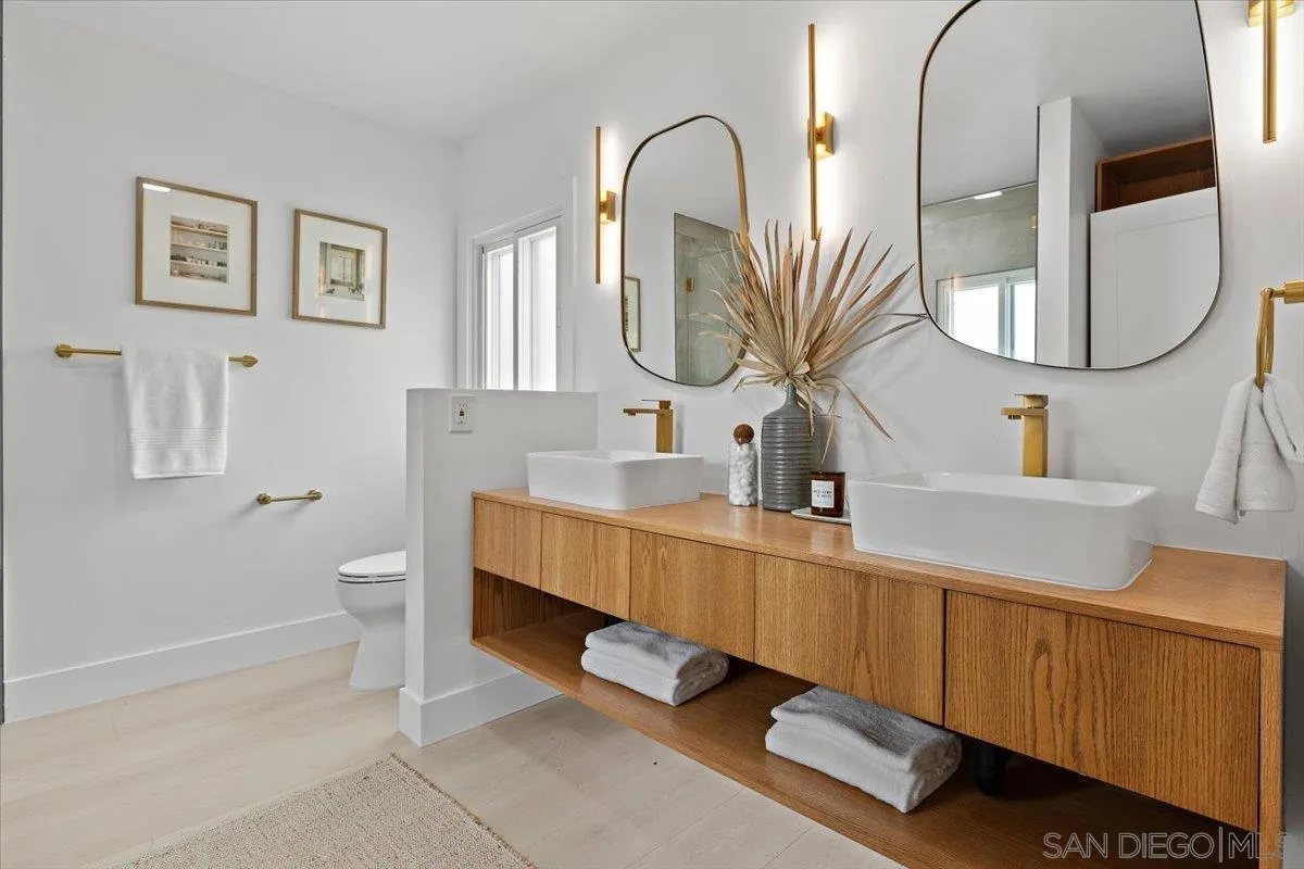 3663 Oleander Drive San Diego, CA 92106 - Photo 26 of 46 a en suite bathroom with a double vanity sink and a mirror