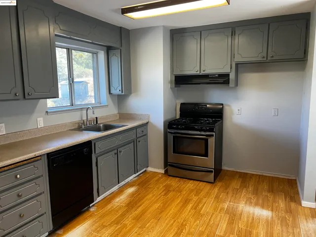 a kitchen with granite countertop a stove and cabinets