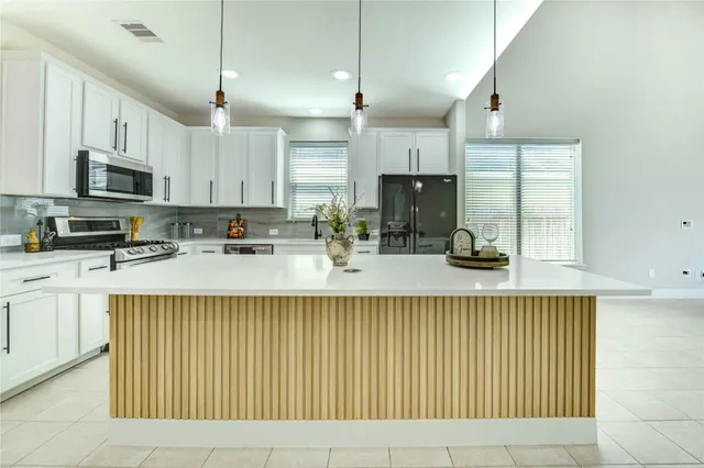 a kitchen with stainless steel appliances a sink a stove and cabinets
