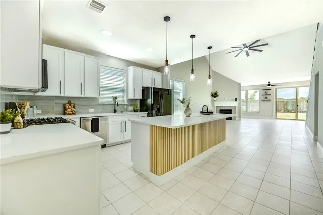 a kitchen with stainless steel appliances kitchen island granite countertop a sink counter top space cabinets and a window