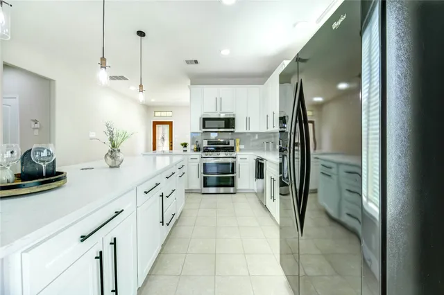 a large kitchen with cabinets and stainless steel appliances