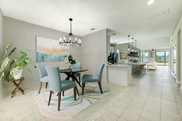 a dining room kitchen island with stainless steel appliances kitchen island granite countertop a table and chairs in it