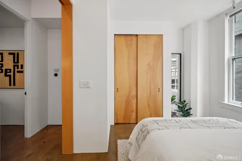 a bedroom with a bed and wooden floor