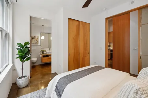 a bedroom with a bed and a potted plant