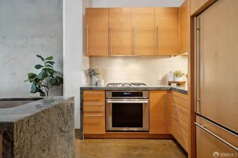 a kitchen with stainless steel appliances a stove a microwave and a potted plant