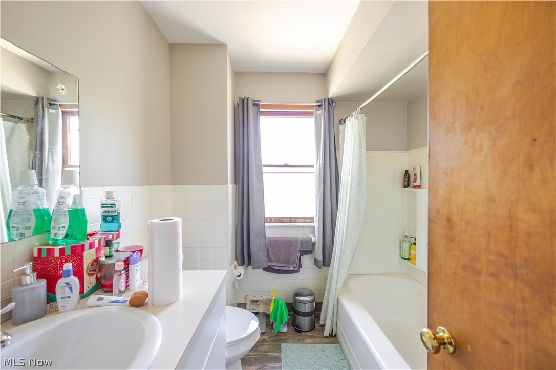 3825 Mayfield Road Cleveland Heights, OH 44121 - Photo 11 of 27 Full bathroom featuring a white vanity with integrated sink, toilet, and a bathtub with shower