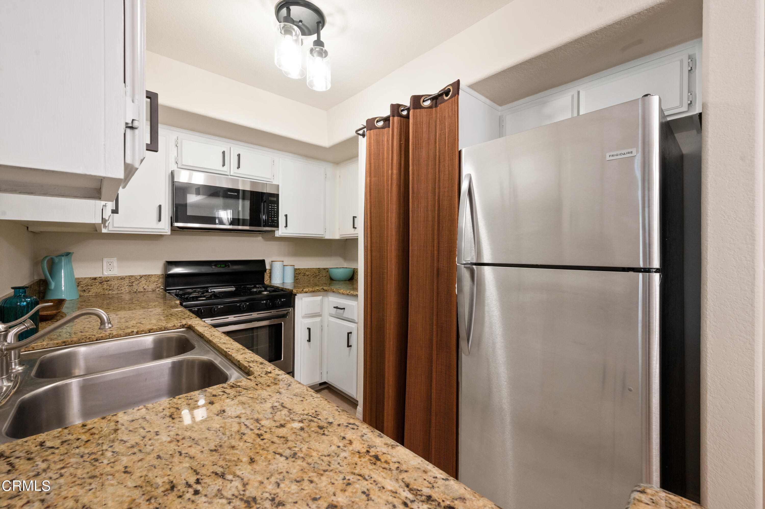 6140 Monterey Road, Unit 220 Los Angeles, CA 90042 - Photo 14 of 43 a kitchen with stainless steel appliances granite countertop a refrigerator a stove a sink a microwave and cabinets