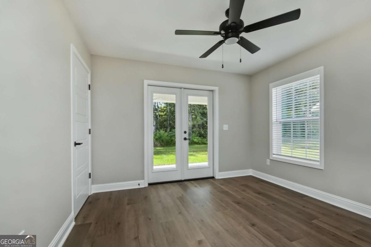 411 Madison Avenue St. Marys, GA 31558 - Photo 11 of 41 an empty room with wooden floor fan and windows