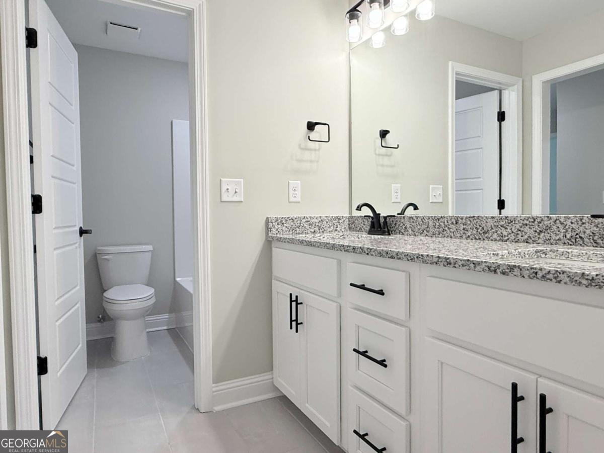 411 Madison Avenue St. Marys, GA 31558 - Photo 24 of 41 a bathroom with a granite countertop toilet sink and mirror