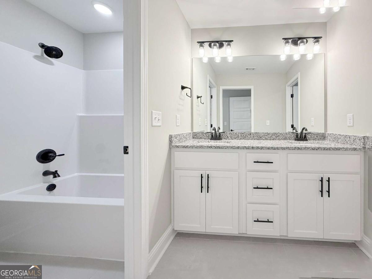 411 Madison Avenue St. Marys, GA 31558 - Photo 25 of 41 a bathroom with a bathtub sink vanity and mirror