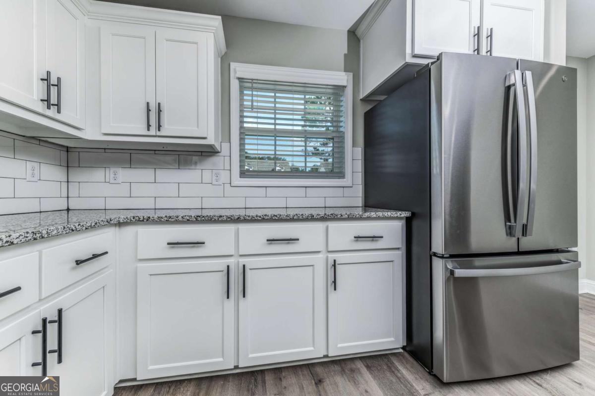 411 Madison Avenue St. Marys, GA 31558 - Photo 5 of 41 a kitchen with stainless steel appliances white cabinets and a granite counter tops