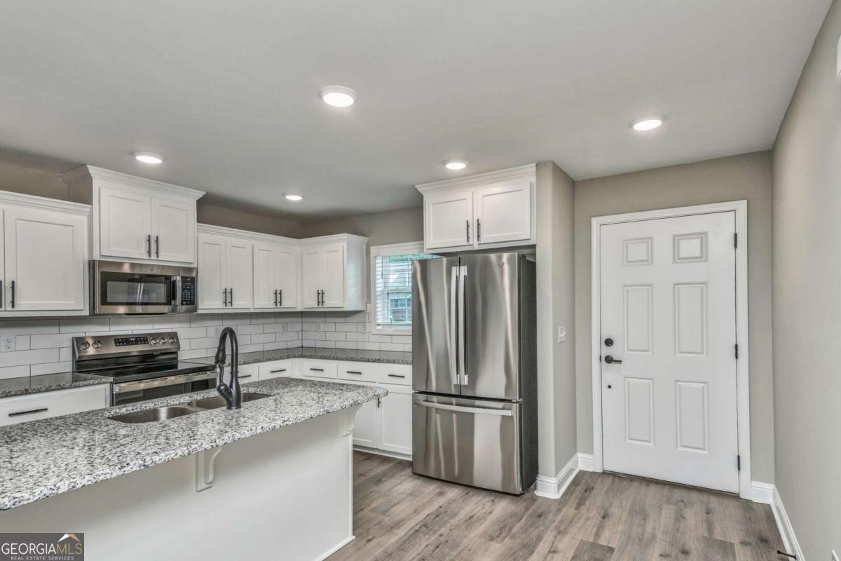 411 Madison Avenue St. Marys, GA 31558 - Photo 7 of 41 a kitchen with stainless steel appliances granite countertop a refrigerator sink and stove