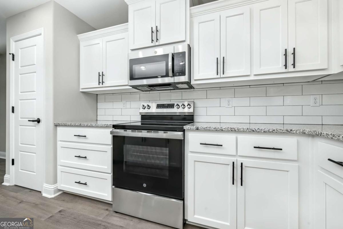 411 Madison Avenue St. Marys, GA 31558 - Photo 8 of 41 a kitchen with white cabinets and stainless steel appliances