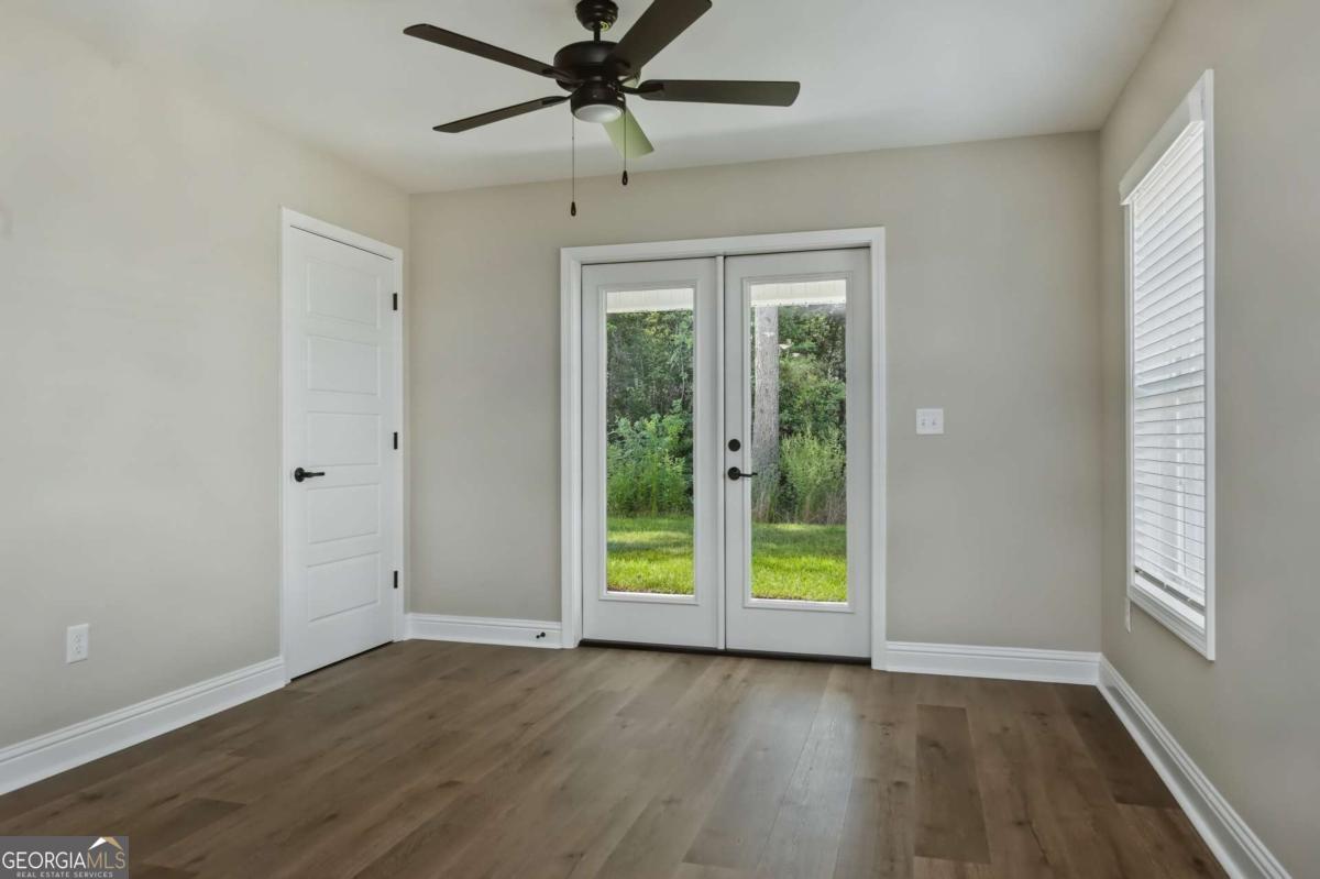 411 Madison Avenue St. Marys, GA 31558 - Photo 9 of 41 an empty room with wooden floor fan and windows