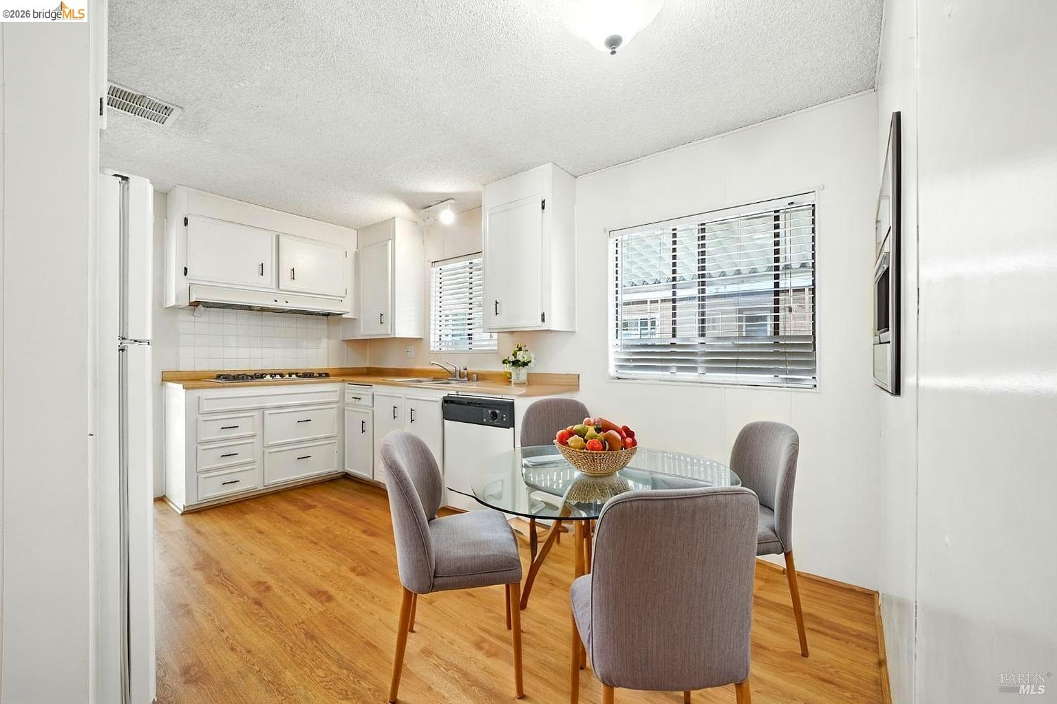 50 Leo Lane, Unit 50 Antioch, CA 94509 - Photo 17 of 64 a kitchen with stainless steel appliances granite countertop a stove a sink dishwasher a dining table and chairs with wooden floor