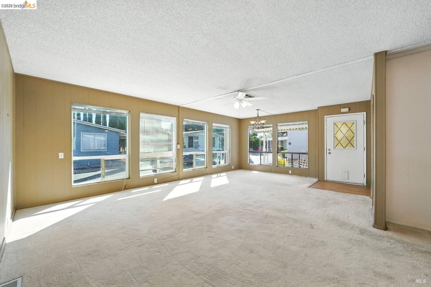 50 Leo Lane, Unit 50 Antioch, CA 94509 - Photo 9 of 64 a view of an empty room with a fireplace and large windows