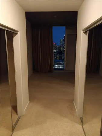 a view of an empty room with closet and a bathroom