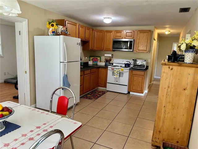 a kitchen with stainless steel appliances granite countertop a refrigerator stove top oven a sink and dishwasher