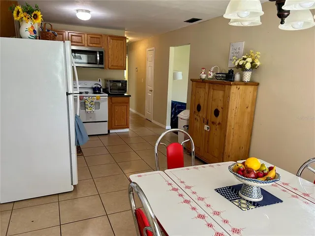 a kitchen with stainless steel appliances a microwave a stove a table and chairs