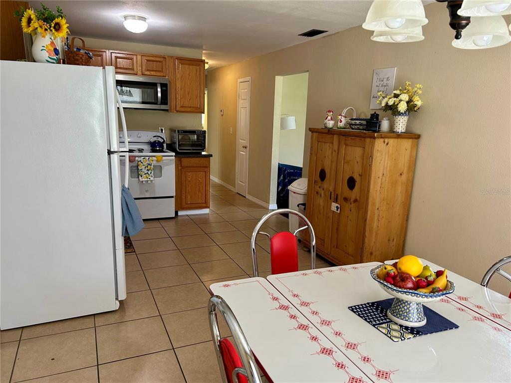 304 Bell Street Wauchula, FL 33873 - Photo 16 of 41 a kitchen with stainless steel appliances a microwave a stove a table and chairs