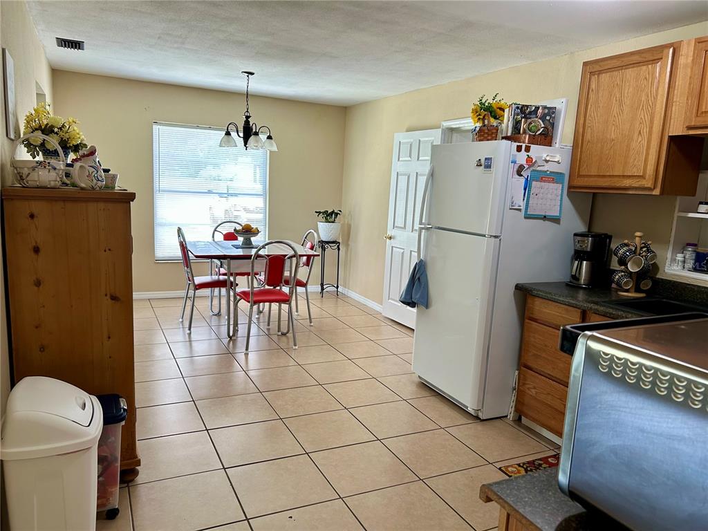 304 Bell Street Wauchula, FL 33873 - Photo 19 of 41 a kitchen with stainless steel appliances a refrigerator a sink a dining table and chairs