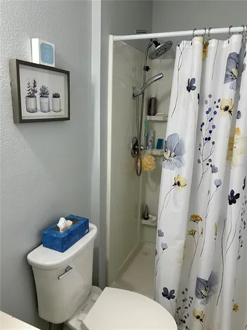 a bathroom with a sink a toilet and shower curtain