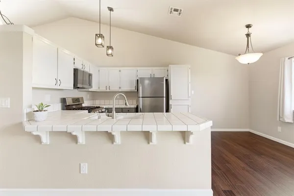 a large white kitchen with kitchen island a stove a sink a center island a stove and a window