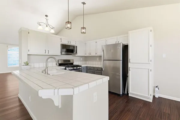 a kitchen with stainless steel appliances a refrigerator sink and microwave