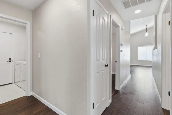 a view of a hallway with wooden floor