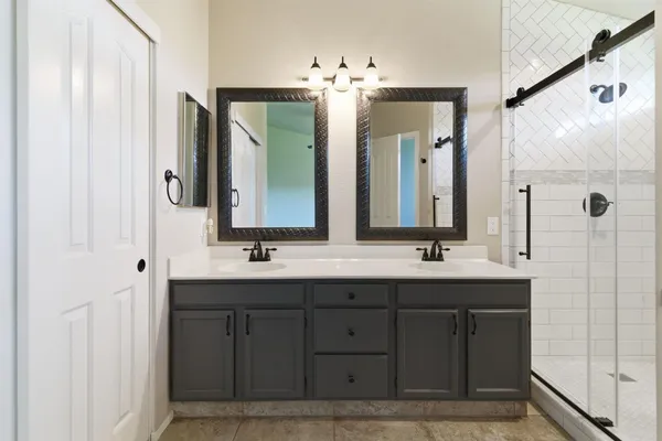 a bathroom with double vanity sinks and a mirror