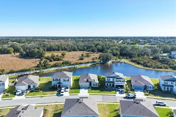 an aerial view of residential houses with outdoor space and parking