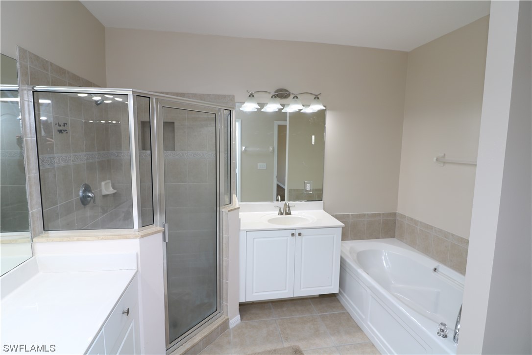 8889 Spring Mountain Way Fort Myers, FL 33908 - Photo 13 of 17 a bathroom with a tub sink shower and mirror