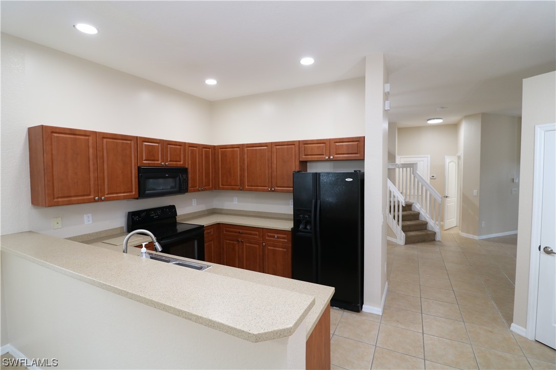 8889 Spring Mountain Way Fort Myers, FL 33908 - Photo 7 of 17 a kitchen with a sink and a refrigerator