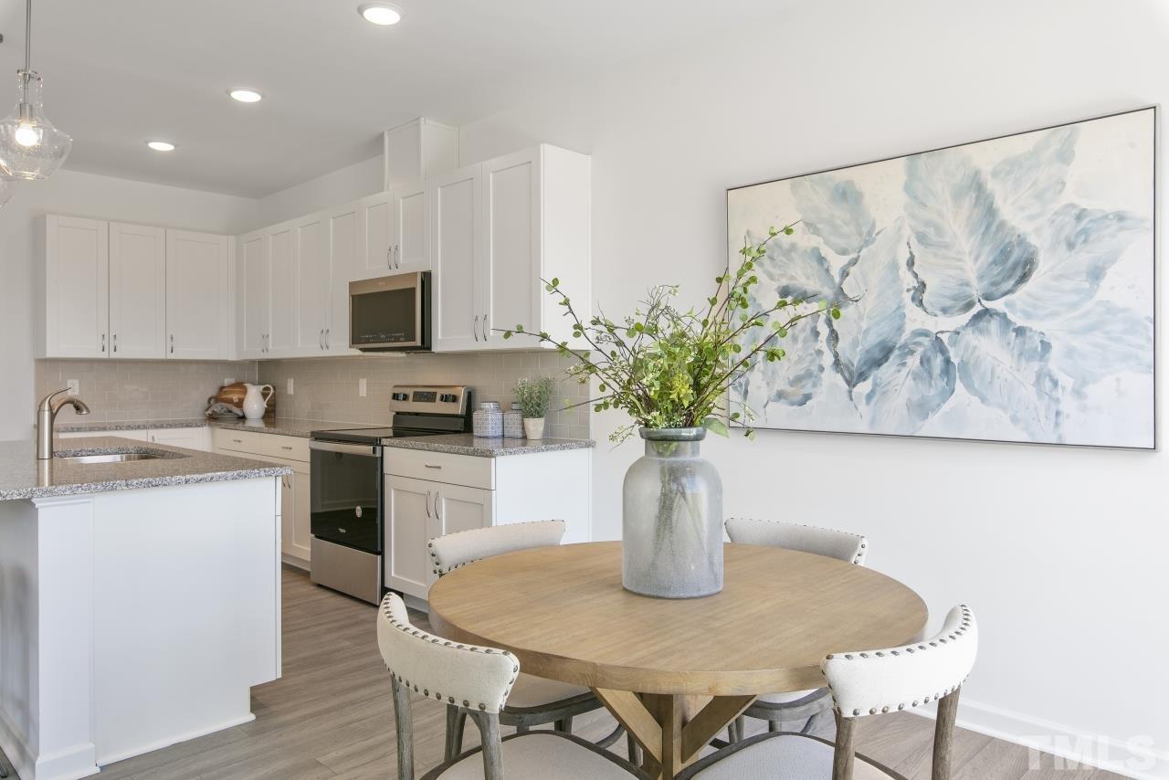 196 Lennei Lane Garner, NC 27529 - Photo 19 of 46 a white kitchen with a stove a sink and a potted plant