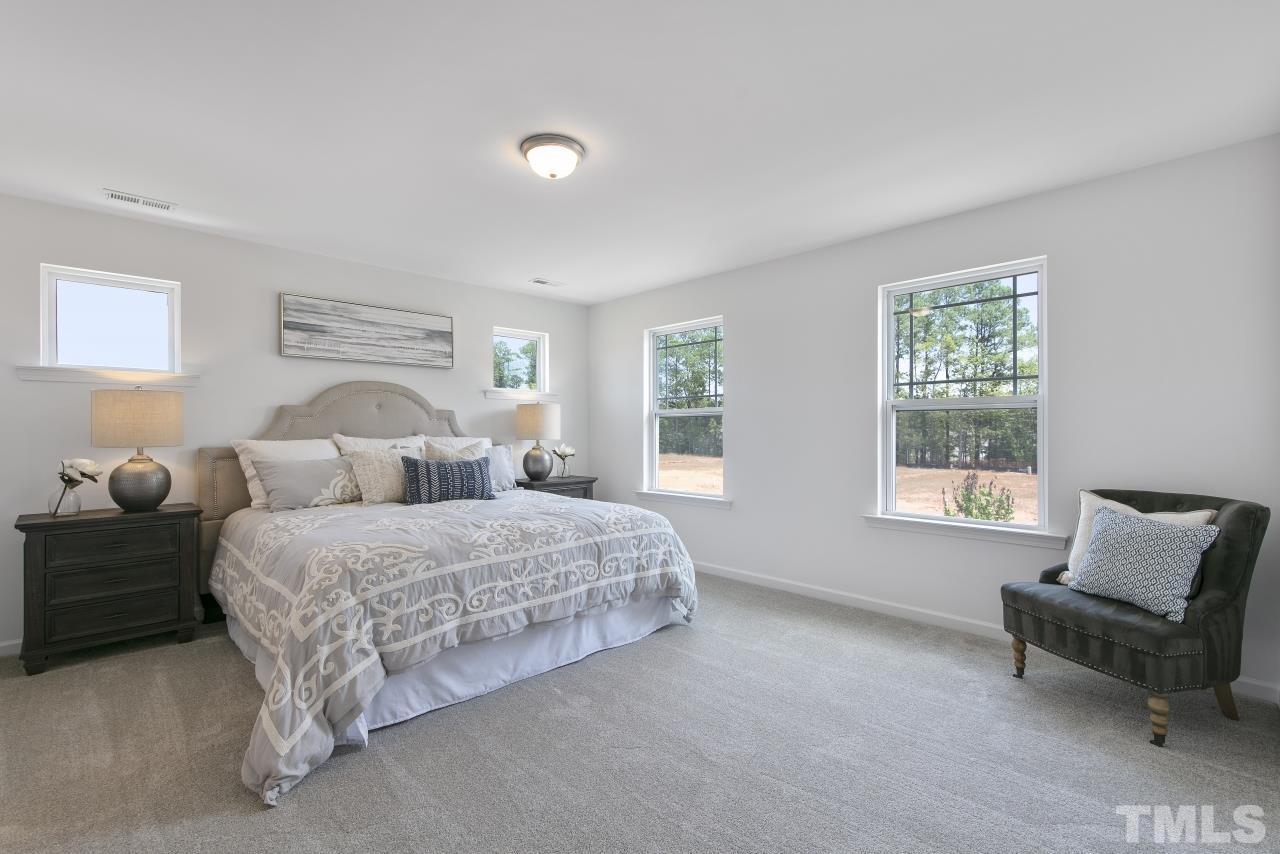 196 Lennei Lane Garner, NC 27529 - Photo 28 of 46 a spacious bedroom with two beds and a couch