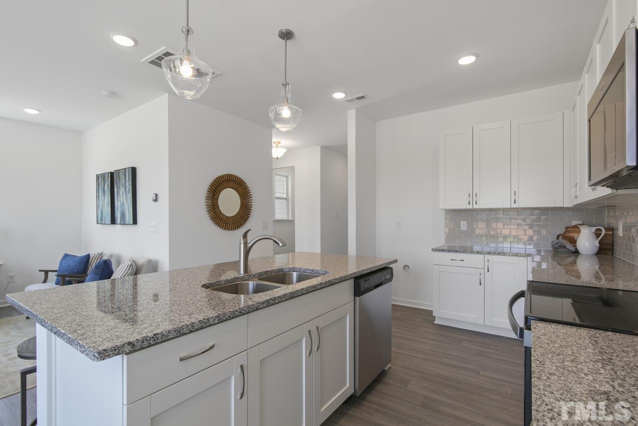 196 Lennei Lane Garner, NC 27529 - Photo 6 of 46 a kitchen with granite countertop a sink a counter space appliances and cabinets