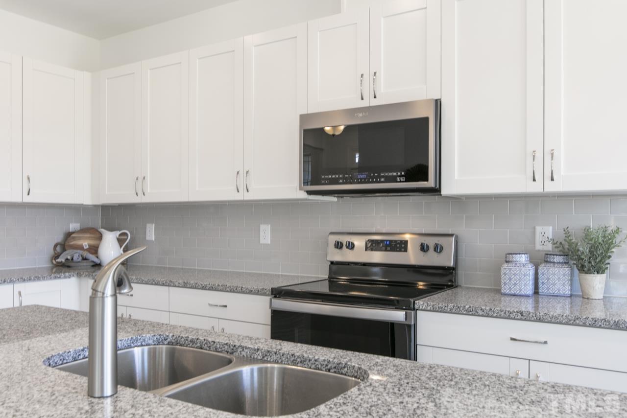 196 Lennei Lane Garner, NC 27529 - Photo 10 of 46 a kitchen with stainless steel appliances granite countertop a sink a stove and microwave