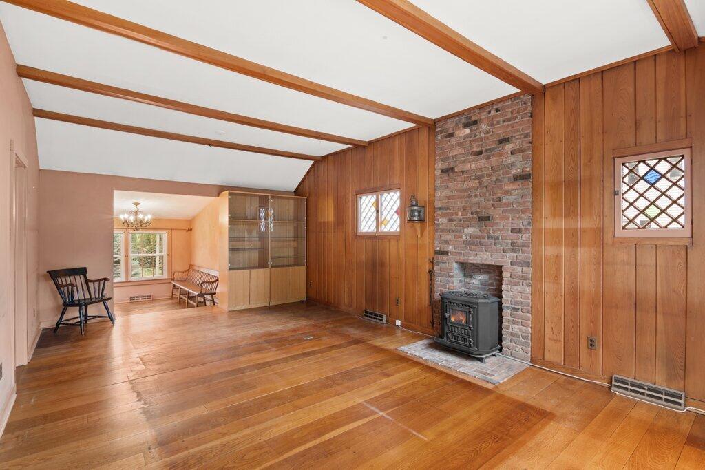 2216 Boston Post Road Darien, CT 06820 - Photo 3 of 31 an empty room with windows a fireplace and wooden floor
