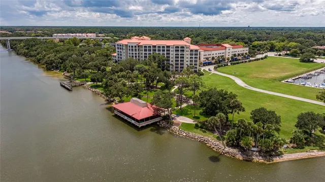 an aerial view of a house with a garden and lake view