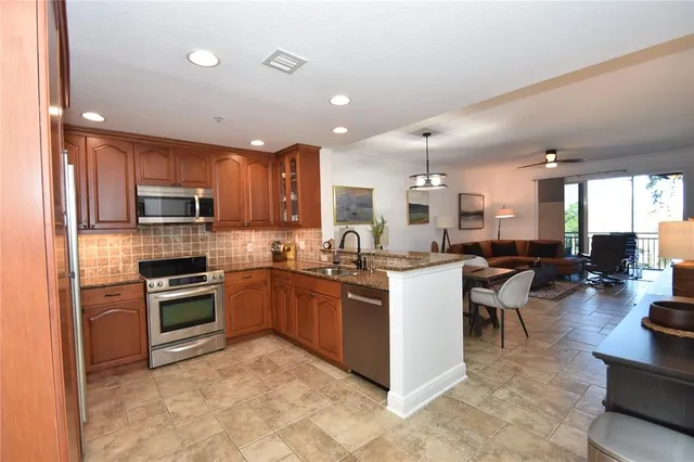 a kitchen with stainless steel appliances granite countertop a sink counter space cabinets and a stove