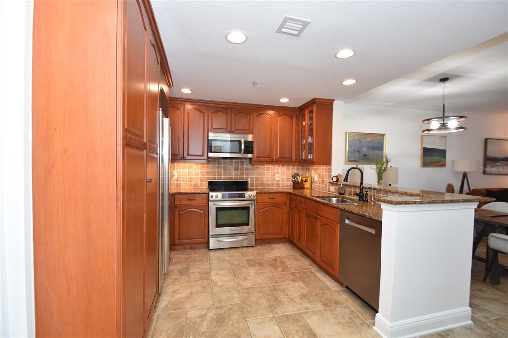 146 Palm Coast Resort Boulevard, Unit 404 Palm Coast, FL 32137 - Photo 8 of 43 a kitchen with stainless steel appliances granite countertop a sink counter space cabinets and a stove