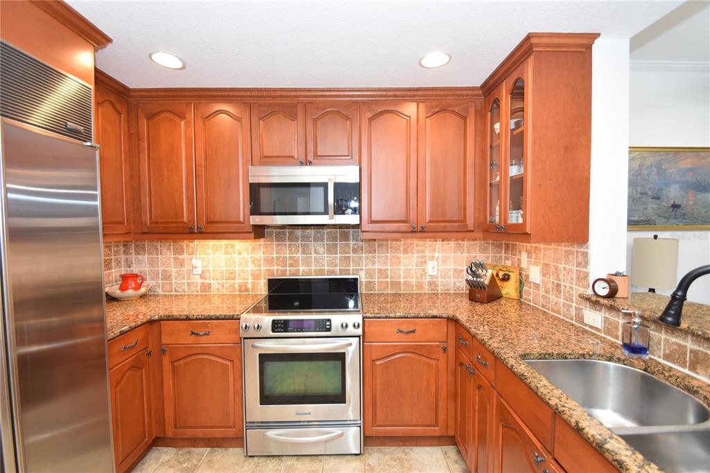 146 Palm Coast Resort Boulevard, Unit 404 Palm Coast, FL 32137 - Photo 10 of 43 a kitchen with stainless steel appliances granite countertop a sink a stove cabinets and a refrigerator