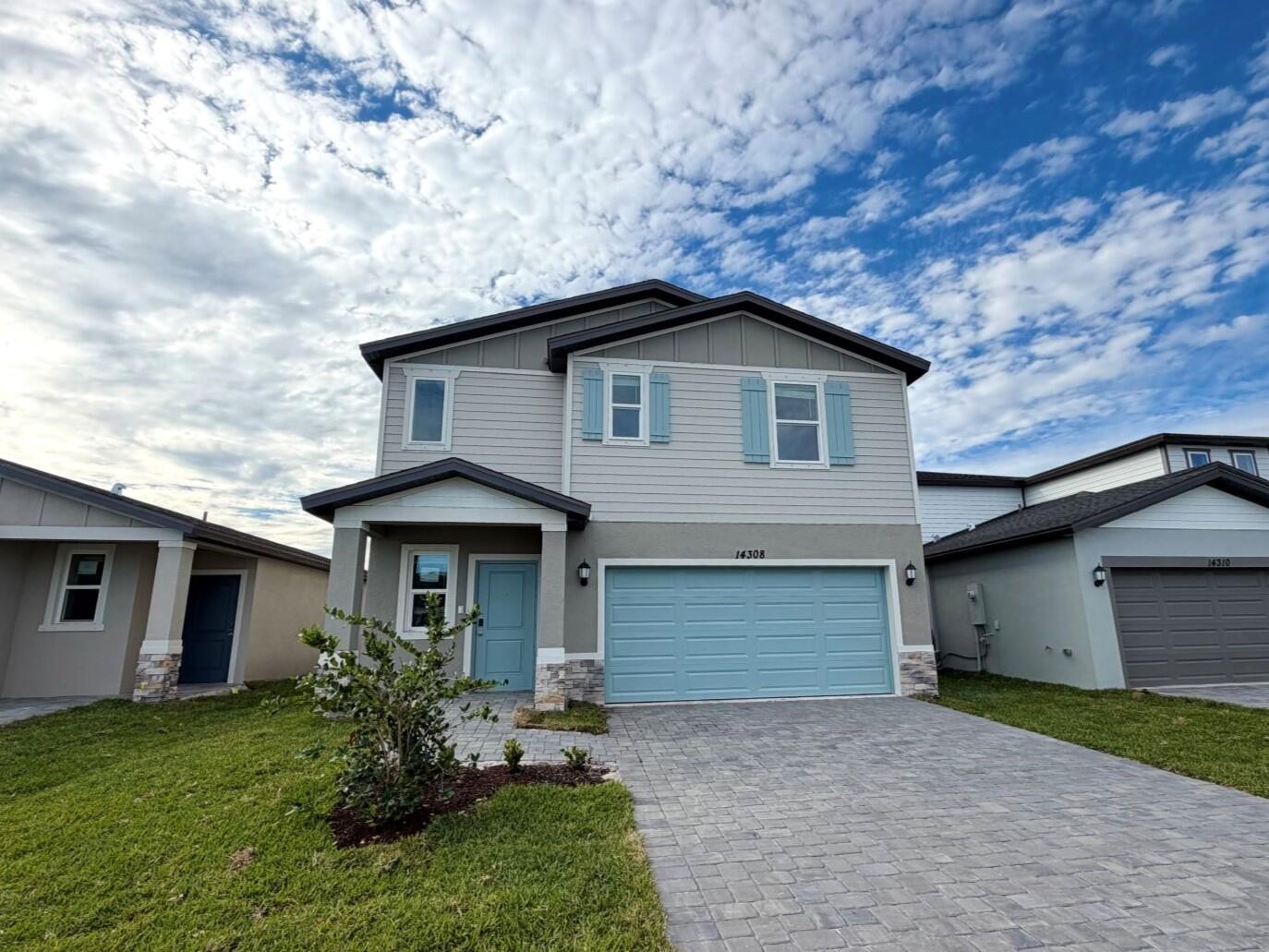 14308 Southwest New Dawn Road Indiantown, FL 34956 - Photo 3 of 11 a front view of a house with a yard and garage