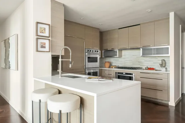 a kitchen with stainless steel appliances granite countertop a stove top oven a sink and a refrigerator