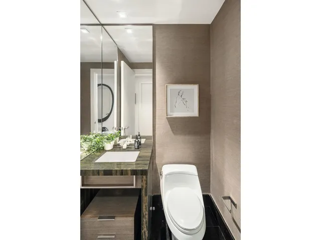 a white toilet sitting next to a bathroom sink