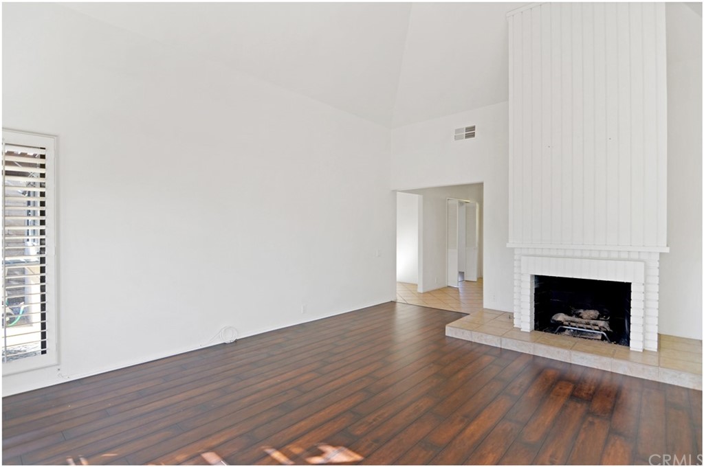 23892 Danzig Bay Dana Point, CA 92629 - Photo 19 of 49 a view of an empty room with wooden floor and a fireplace