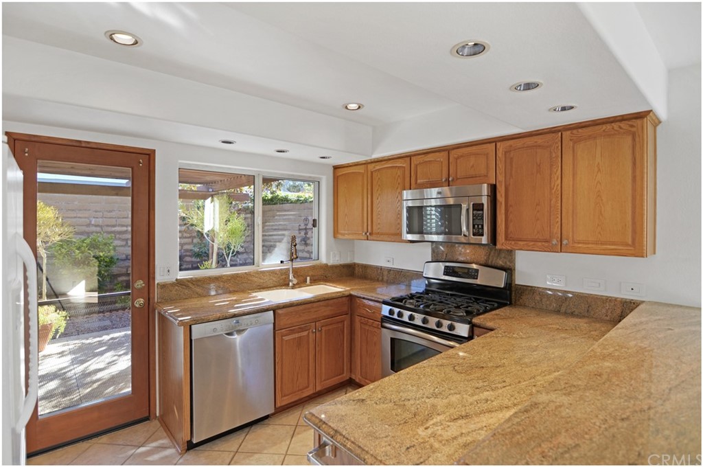 23892 Danzig Bay Dana Point, CA 92629 - Photo 7 of 49 a kitchen with stainless steel appliances granite countertop a stove a sink and a refrigerator