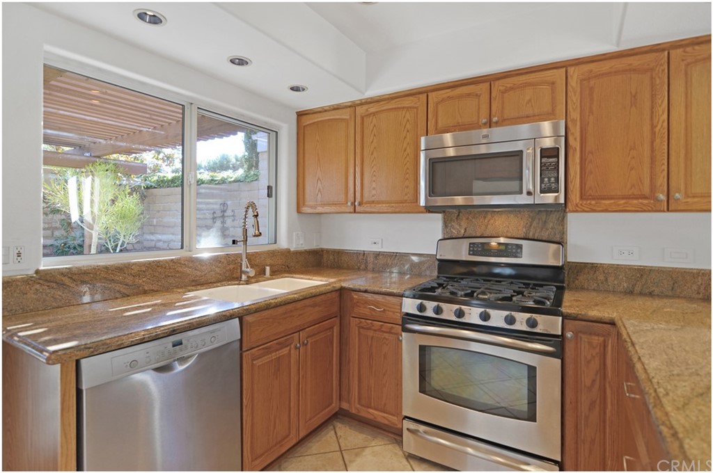 23892 Danzig Bay Dana Point, CA 92629 - Photo 8 of 49 a kitchen with stainless steel appliances granite countertop a stove sink and microwave